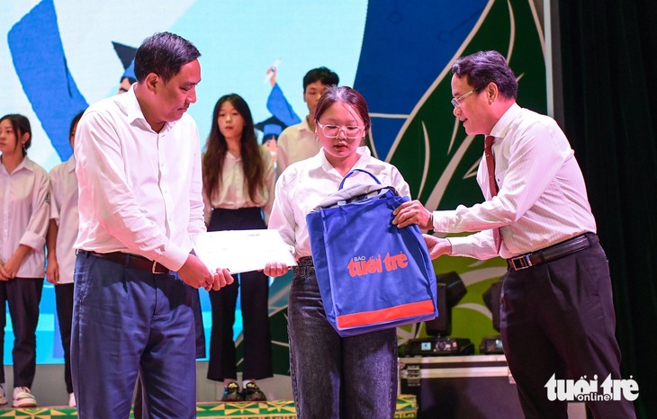 Ông Hoàng Giang, phó bí thư tỉnh ủy Lào Cai (trái) cùng ông Hoàng Nguyên, phó Tổng biên tập báo Tuổi Trẻ trao học bổng, giấy chứng nhận cho các bạn tân sinh viên - Ảnh: NAM TRẦN
