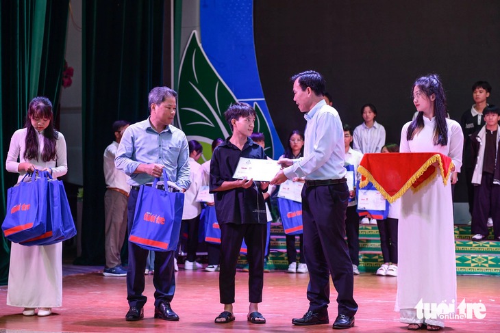 Ông Dương Đức Huy, trưởng ban Tuyên giáo tỉnh ủy Lào Cai (phải) và ông Nguyễn Thế Dũng, phó giám đốc Sở giáo dục đào tạo Lào Cai trao học bổng cho các tân sinh viên - Ảnh: NAM TRẦN